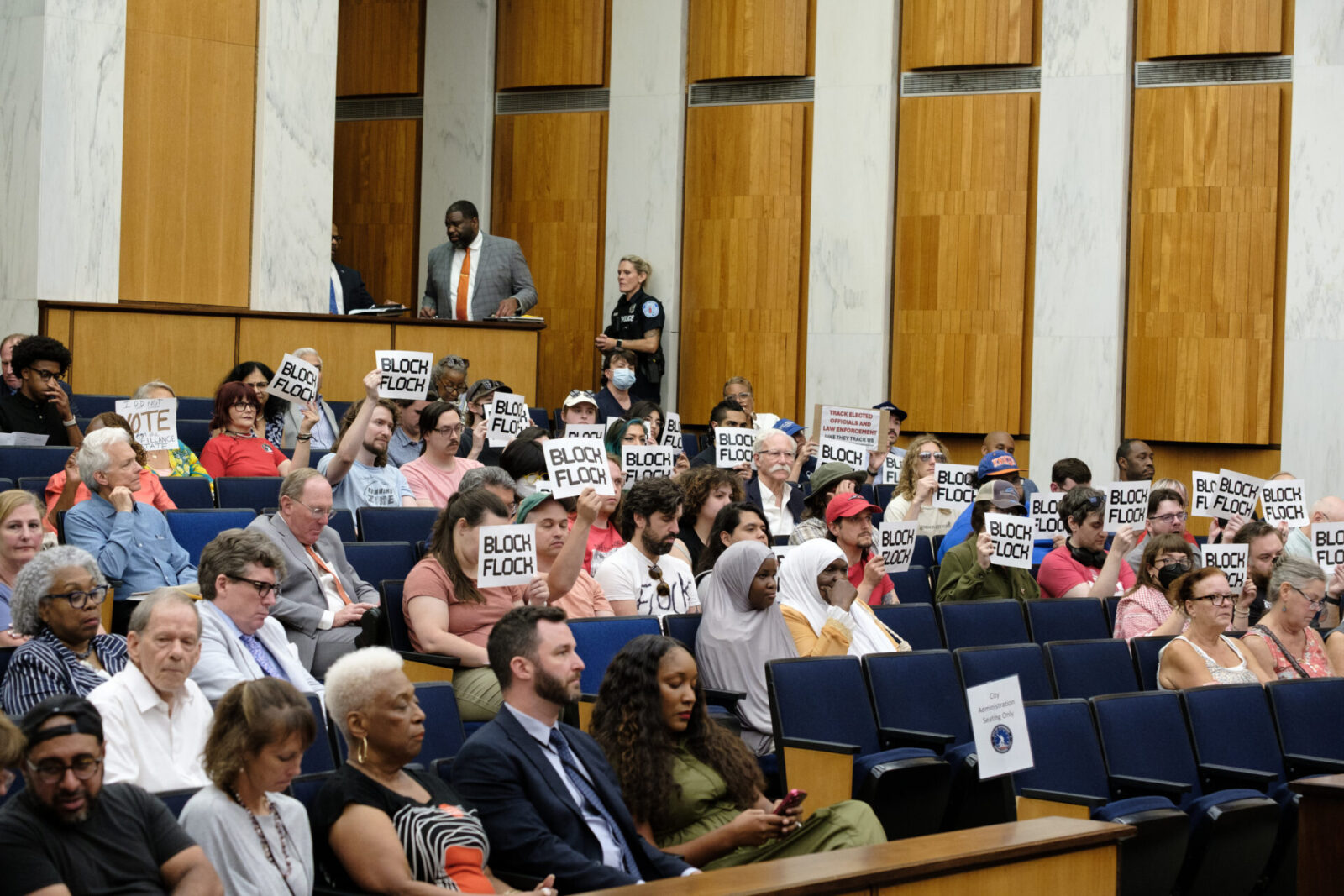 Community advocates holding BLOCK FLOCK signs at a Richmond City Council meeting.